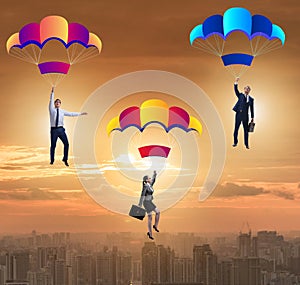 Business people falling down on parachutes