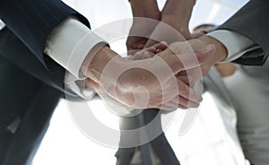 Business people folding their hands together.