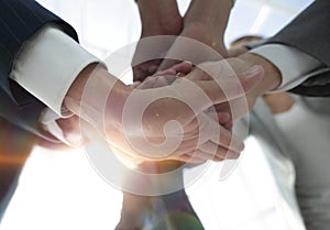 Business people folding their hands together.