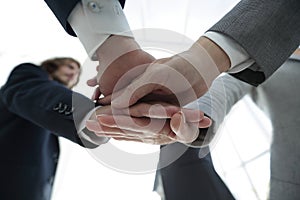 Business people folding their hands together.