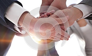 Business people folding their hands together.