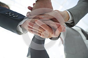 Business people folding their hands together.