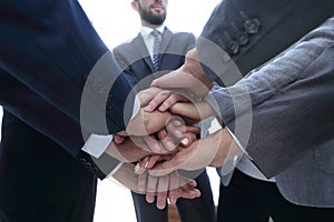 Business people folding their hands together.