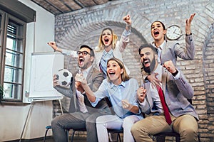 Business people or football fans watching soccer on tv and celebrating victory. Friendship, sports and entertainment concept