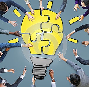 Business People Forming a Light Bulb Puzzle