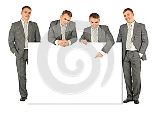 Business people of four with board for text