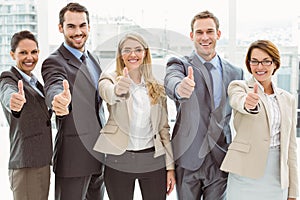 Business people gesturing thumbs up in office