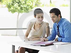 Business People Going Over Document Information At Desk