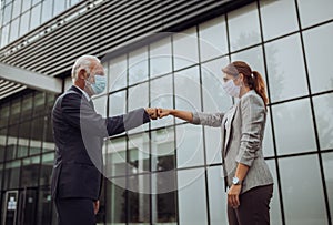 Business people greeting with fist bump in street