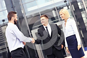 Business people greeting outside modern building