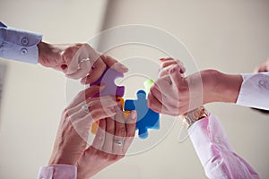 Business people group assembling jigsaw puzzle