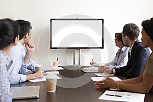 Business people group sitting at conference table looking at screen photo