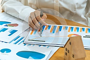 Business people hand working and calculating about graph chart finance with document report on desk