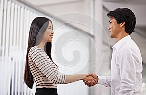 Business people, handshake and meeting with agreement for deal or proposal together at the office. Young asian man and