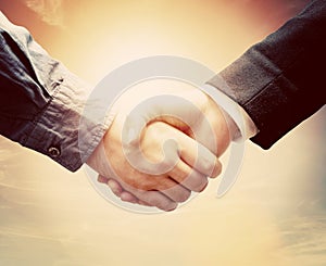 Business people handshake. Sunny vintage sky