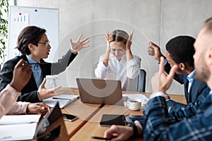 Business People Having Conflict Shouting At Unhappy Businesswoman At Workplace photo