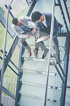 Business people having conversation on stairs of business build