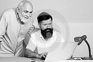 Business people having meeting around table in modern color office. Two businessman sitting at the table typing on