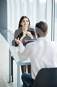 Business people man and woman Having Meeting at Table In Modern Office against panoramic windows. Focus on woman.