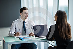 Business people Having Meeting Around Table In Modern Office. Young man listen woman in office