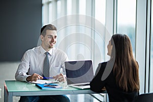 Business people Having Meeting Around Table In Modern Office. Young man listen woman in office