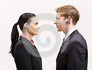 Business people in headsets standing face to face