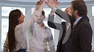 Business people hihg-fiving at the office