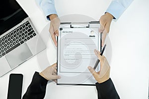 Business people hold a resume and talk to job applicants for job interviews about careers and Their personal history in the