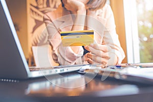 Business people holding credit cards and using laptops shopping online