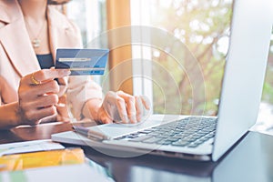 Business people holding credit cards and using laptops shopping online