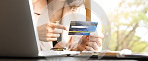 Business people holding credit cards and using laptops shopping online