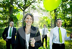 Business People Holding Green Balloon In Forest