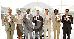 Business people holding letters spelling success