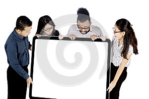 Business people holding whiteboard on studio