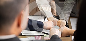 Business people join punching fists bump hands as team their meeting