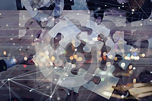 Business people join puzzle pieces in office. Concept of teamwork and partnership. double exposure with internet network