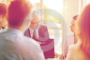 Business people with laptop meeting in office