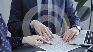 Business people or lawyers are discussing contract terms before signing. Close-up of a man and woman sitting at the desk