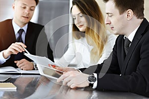 Business people or lawyers discussing questions at meeting in sunny office. Unknown businessman and woman with colleague