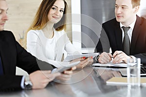 Business people or lawyers discussing questions at meeting in sunny office. Unknown businessman and woman with colleague