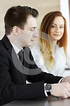 Business people or lawyers discussing questions at meeting in sunny office. Unknown businessman and woman with colleague