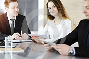 Business people or lawyers discussing questions at meeting in sunny office. Unknown businessman and woman with colleague