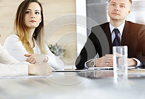 Business people or lawyers discussing questions at meeting in sunny office. Unknown businessman and woman with colleague
