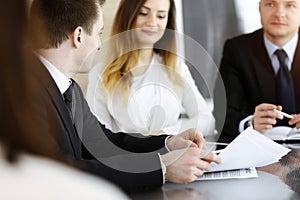 Business people or lawyers discussing questions at meeting in sunny office. Unknown businessman and woman with colleague