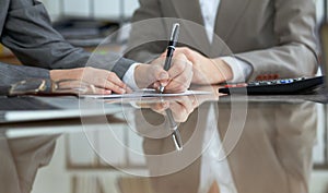 Business people or lawyers signing contract at meeting. Close-up of human hands at work