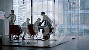 Business people listening the presenter while sitting at desk