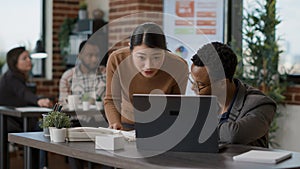 Business people looking at documents charts and laptop