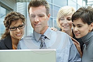 Business people looking at laptop