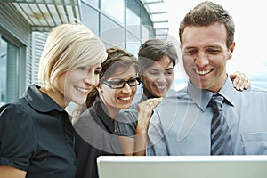 Business people looking at laptop