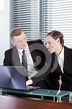 Business people looking at laptop